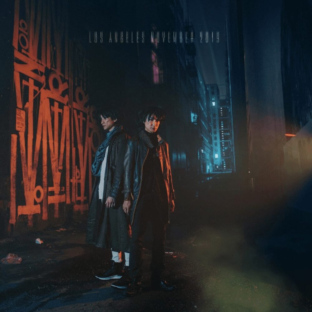 Electronic pop duo Ming and Ping pose in a street at night.